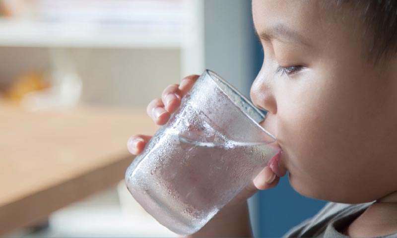 コップから水を飲む子供