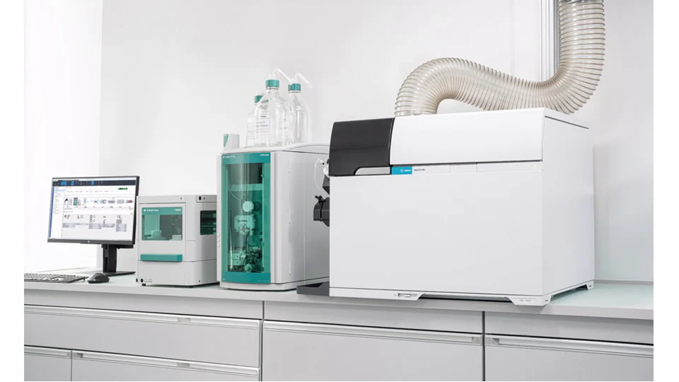 Modern laboratory setup featuring advanced analytical equipment, including an ion chromatograph, autosampler, ICP-MS, and computer monitor on a counter.