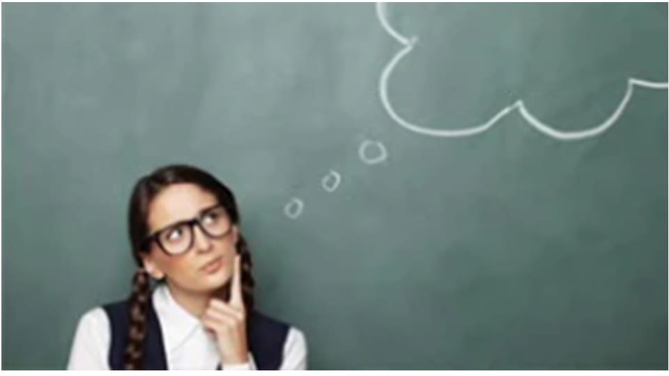 A person in front of a chalkboard, pondering, with a hand on their chin. A thought bubble is drawn above their head.